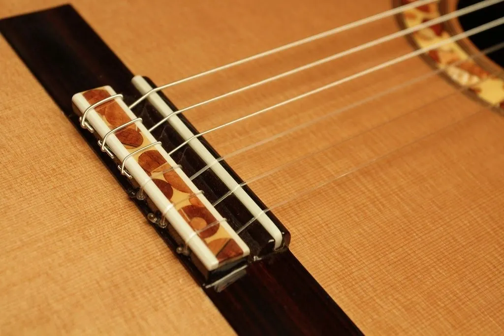 A close up picture of a six string guitar in dusky brown color