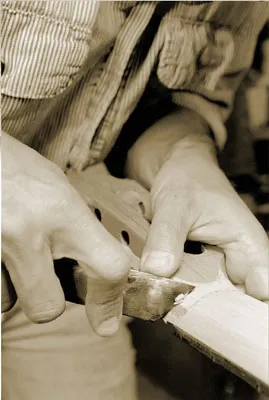 A person crafting a guitar for the use of music