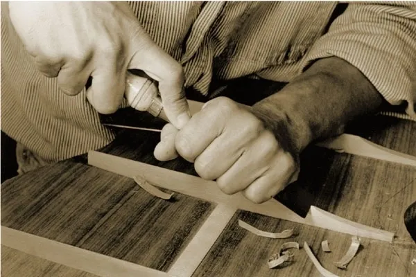 A person crafting a design base for the guitar